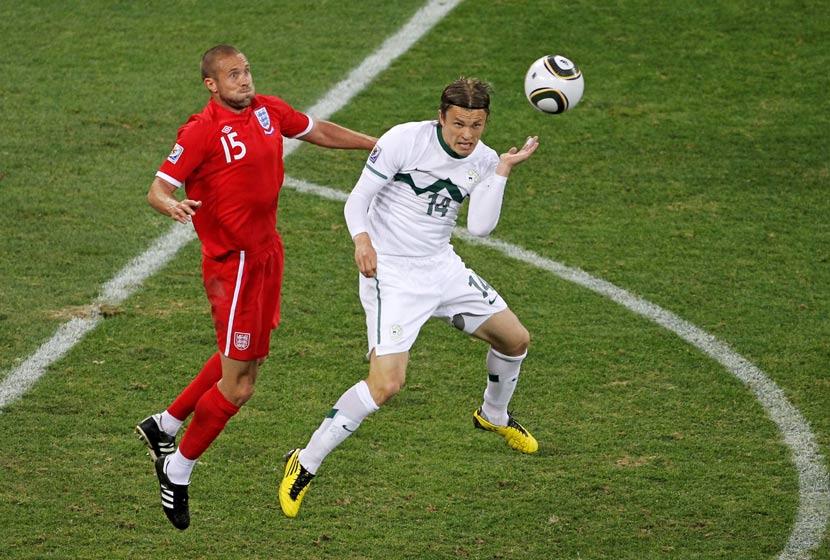 Matthew Upson contests a high ball with Slovenia's Zlatko Dedic.